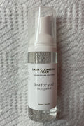 Lash cleansing foam bottle labeled 'Just for you!' on a textured gray background